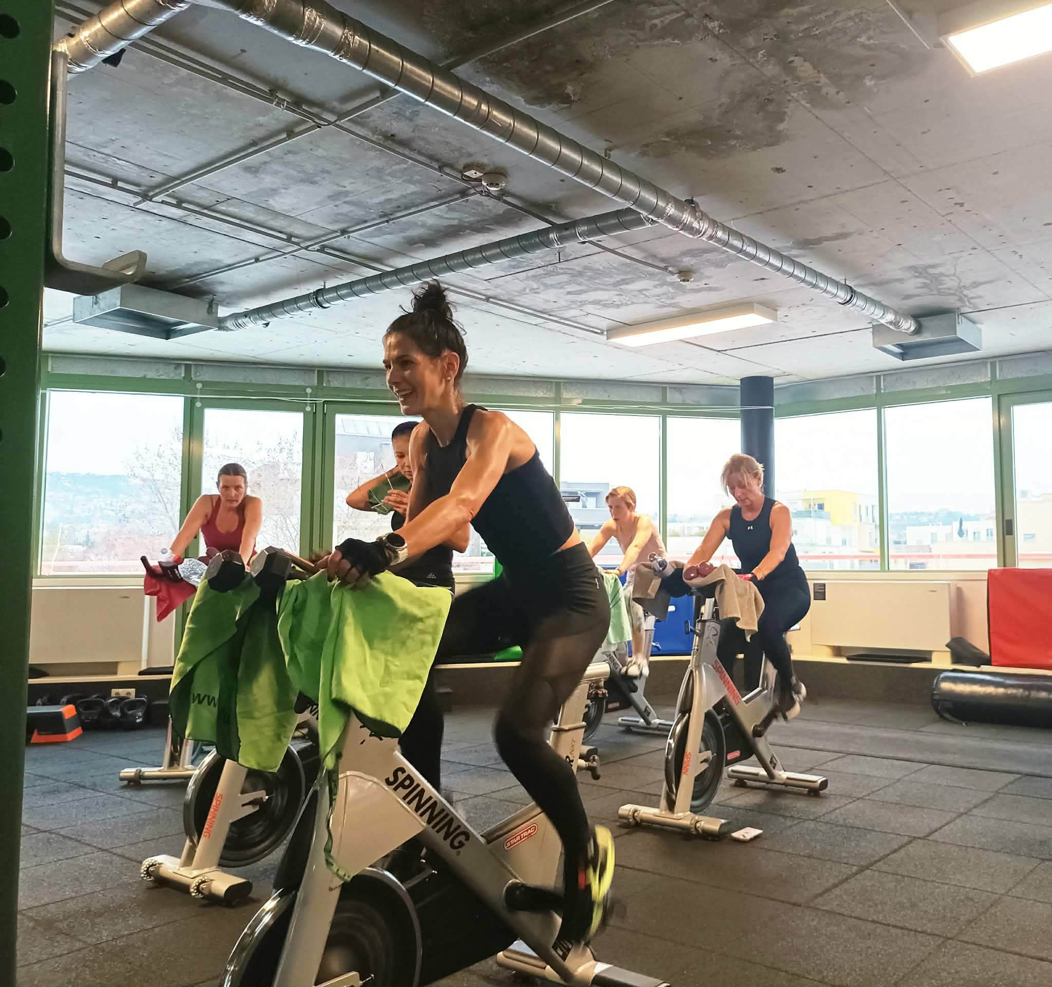 Fusion-BIKE óra a teremben, a résztvevők a spinning-kerékpárokon dolgoznak