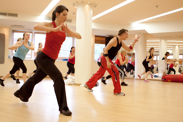 FitFusion óra dinamikus koreográfia közben, a résztvevők oldalirányú kitörésben